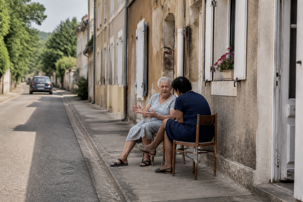 Rue bien entretenue avec habitants discutant paisiblement dehors