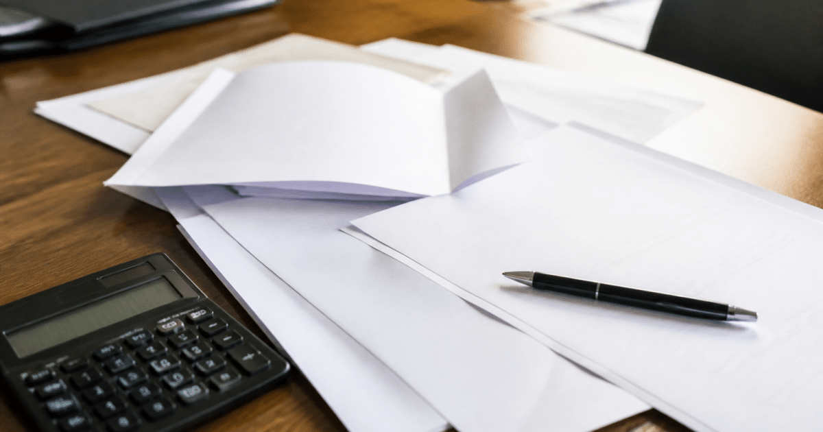 Documents notariaux etales sur bureau avec stylo et calculatrice