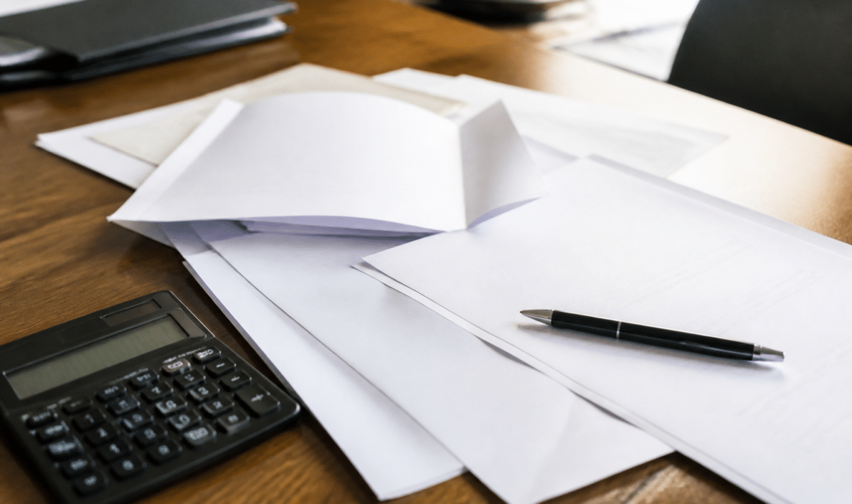 Documents notariaux etales sur bureau avec stylo et calculatrice