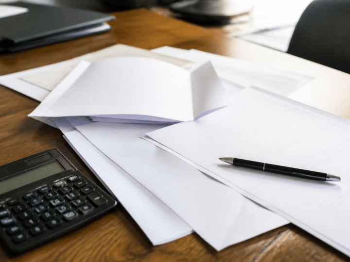 Documents notariaux etales sur bureau avec stylo et calculatrice