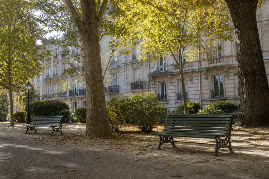 Parc ombrage avec facades residentielles et bancs publics