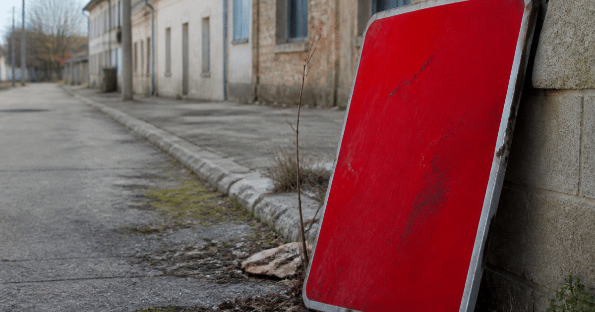 Panneau d'avertissement rouge sur rue urbaine abandonnee