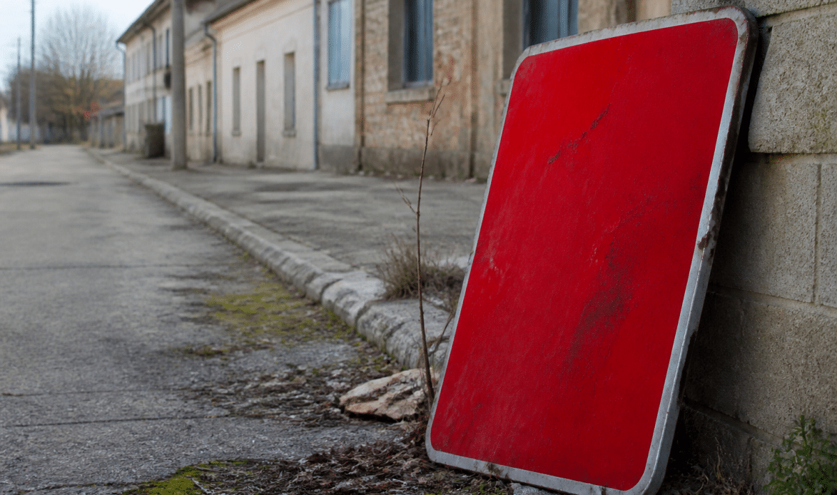 Panneau d'avertissement rouge sur rue urbaine abandonnee