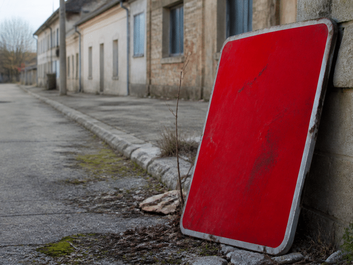 Panneau d'avertissement rouge sur rue urbaine abandonnee