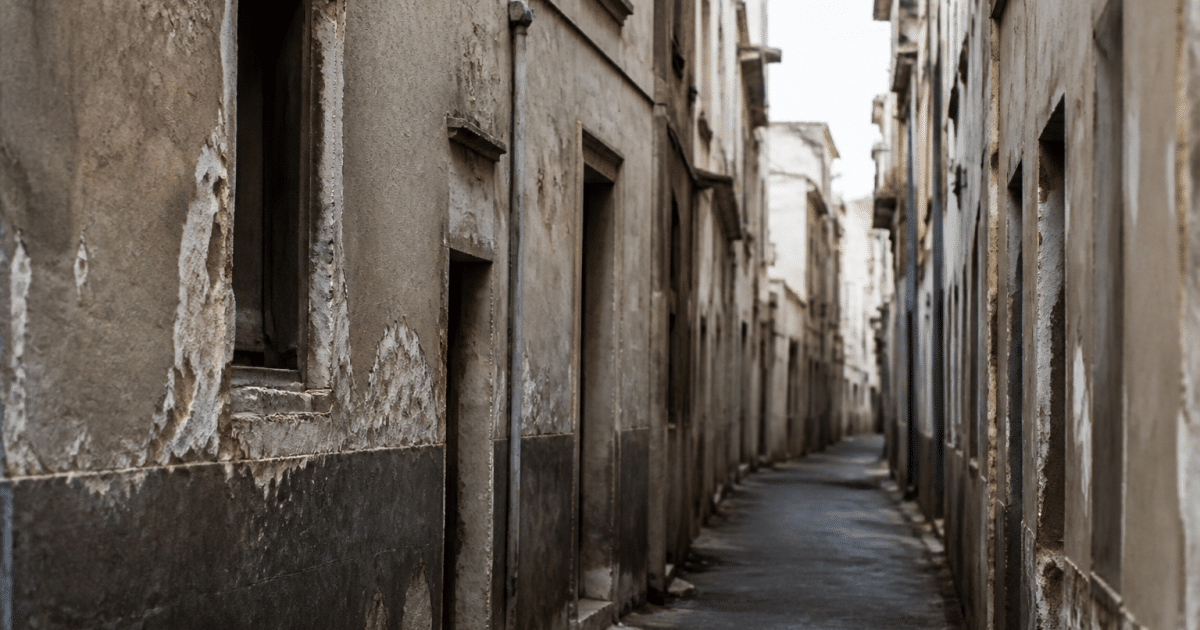 Rue etroite et deterioree avec immeubles delabres et facades usees