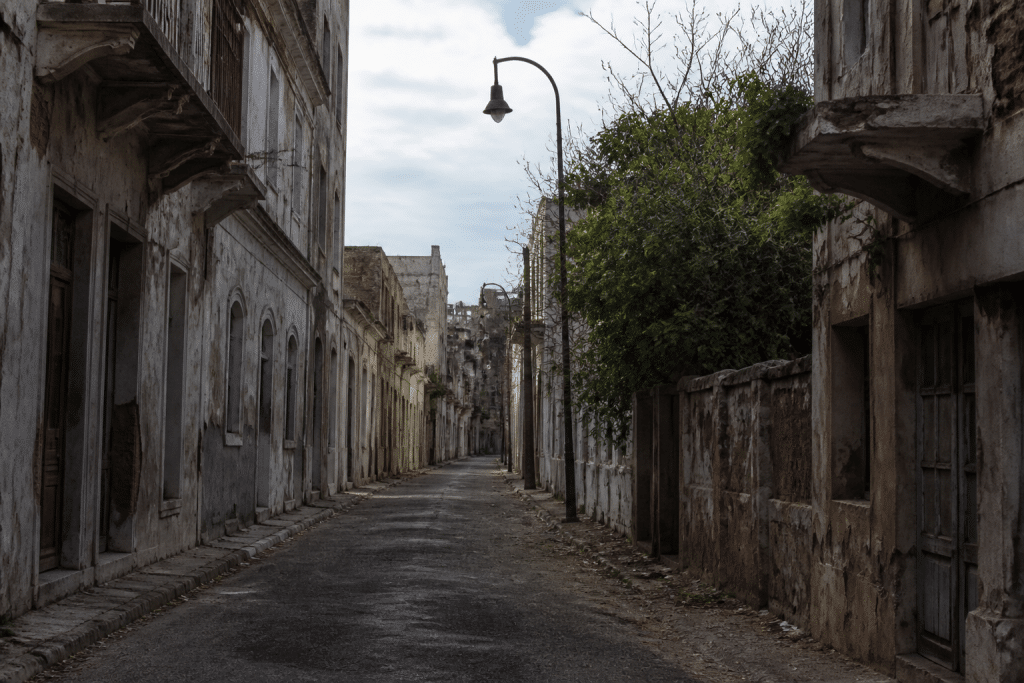 Rue sombre avec immeubles délabres et lampadaires eteints