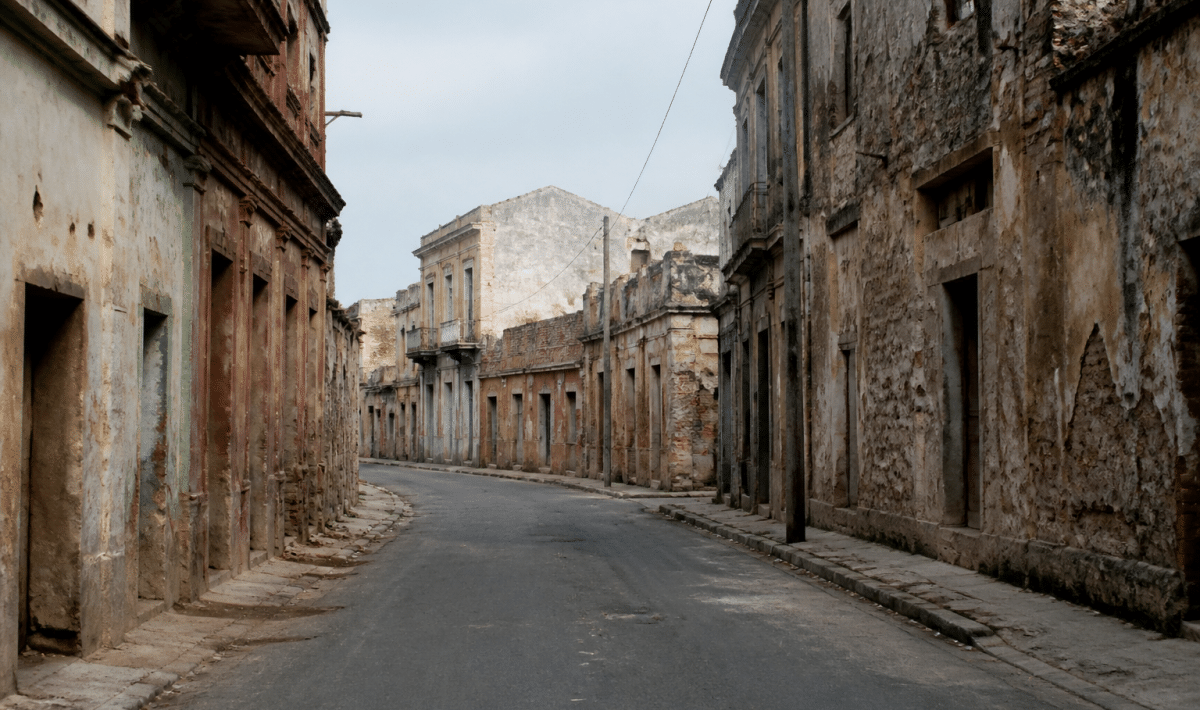 Rue urbaine degradee avec batiments anciens delabres et deserts