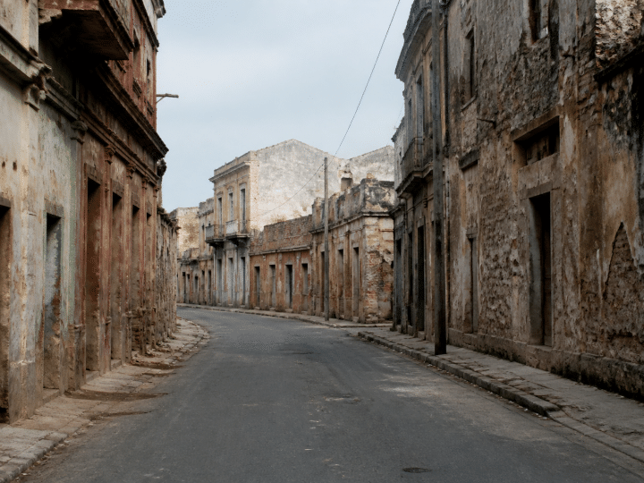 Rue urbaine degradee avec batiments anciens delabres et deserts