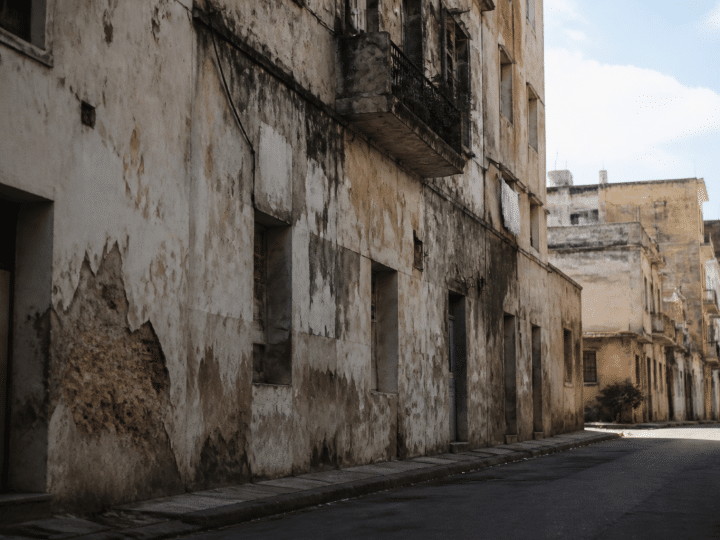 Rue urbaine degradee avec immeubles delabres et facades usees