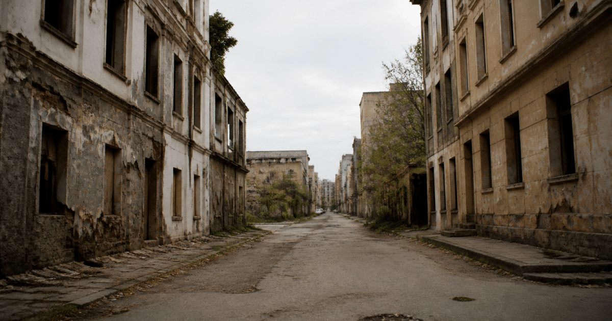 Rue urbaine deserte avec immeubles abandonnes et façades degradees