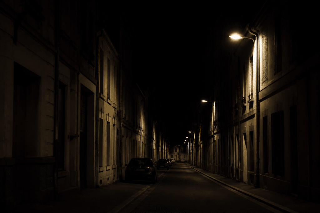 Rue urbaine sombre avec lampadaires faibles la nuit