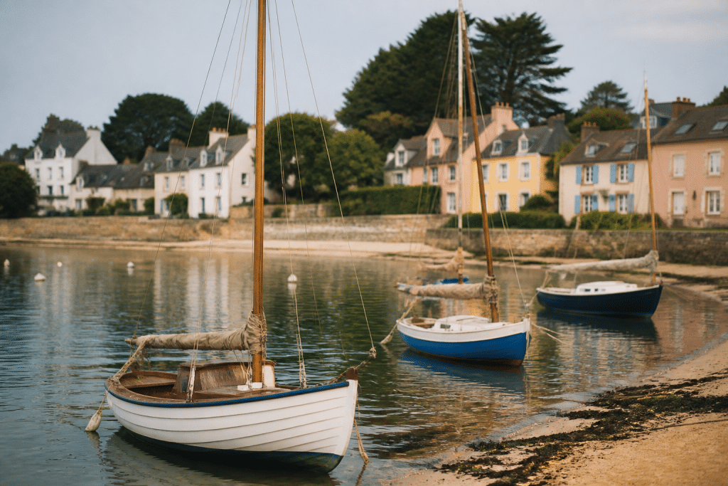 Voiliers amarres pres plage calme avec maisons colorees