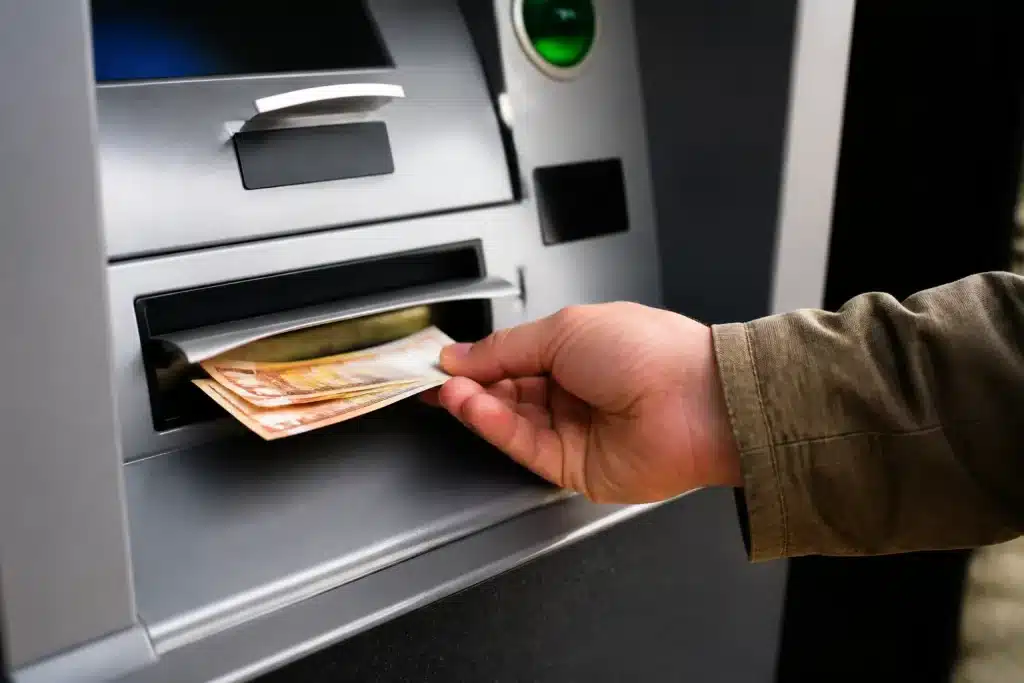Personne retirant argent liquide du distributeur automatique