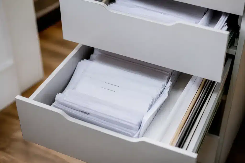 Tiroirs ouverts contenant relevés bancaires et contrats papier