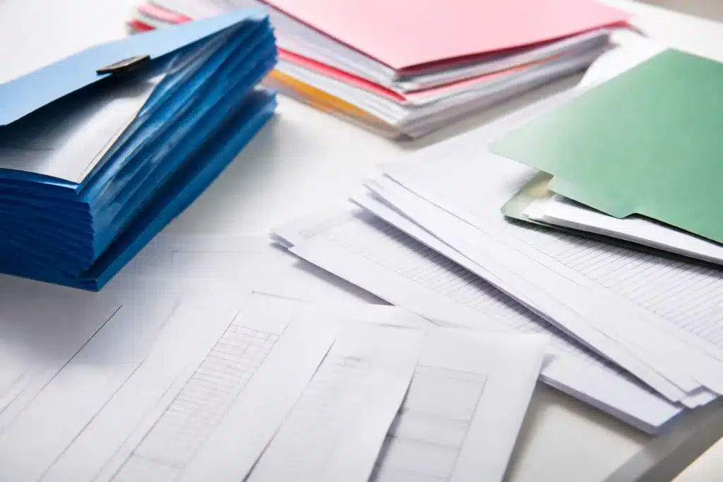 Documents administratifs étalés sur bureau blanc