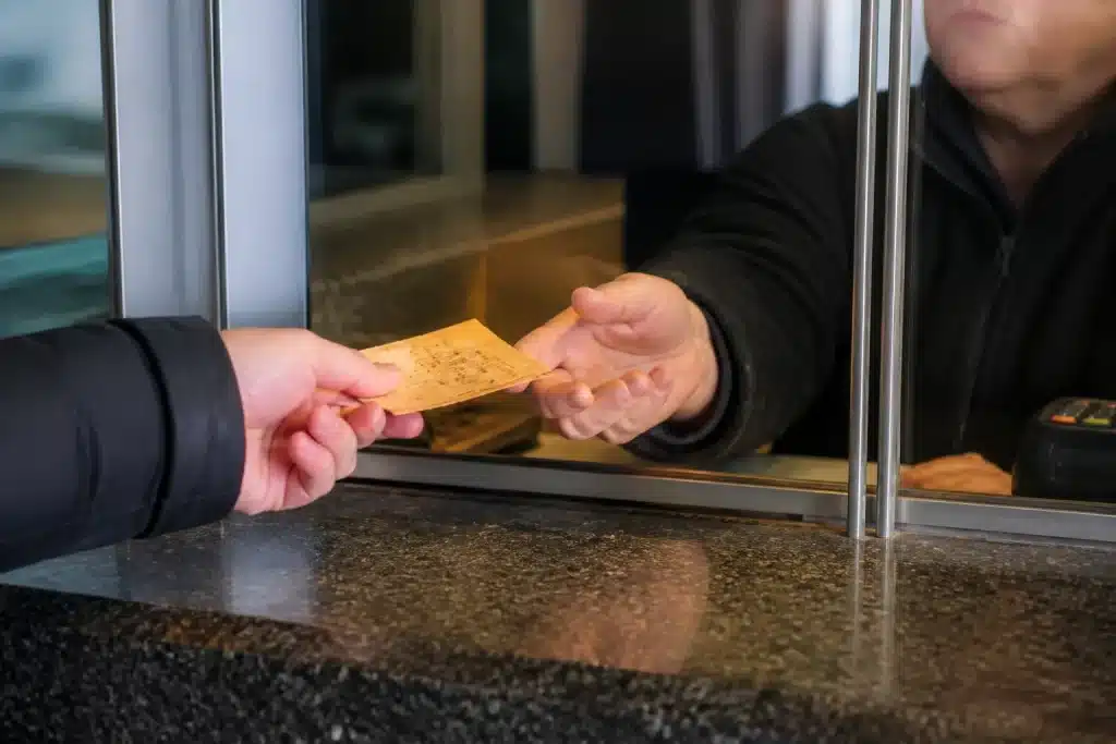 Personne echangeant vieux tickets papier au comptoir