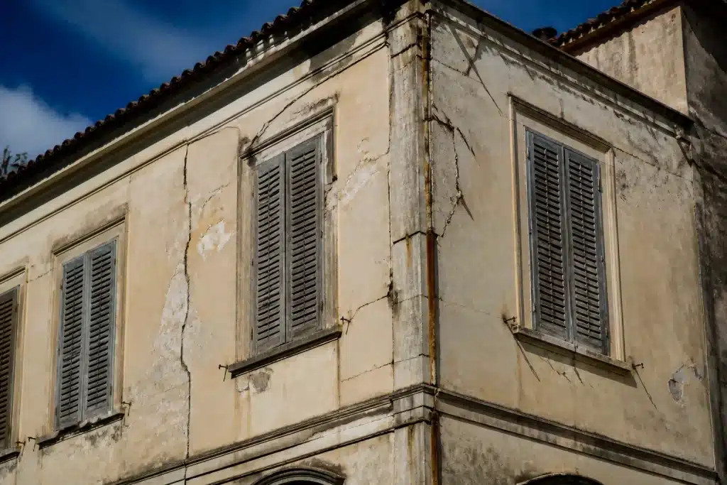 Batiment ancien avec facades fissurees montrant signes usure