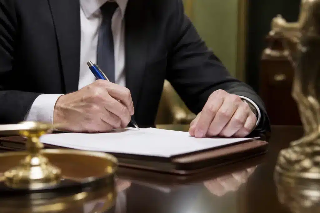 Notaire signant document légal avec stylo bleu
