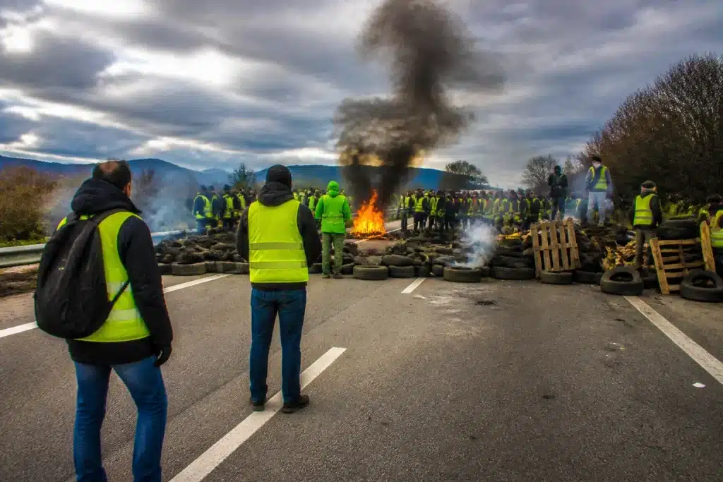 Manifestants en gilets jaunes bloquant route avec pancartes protestation