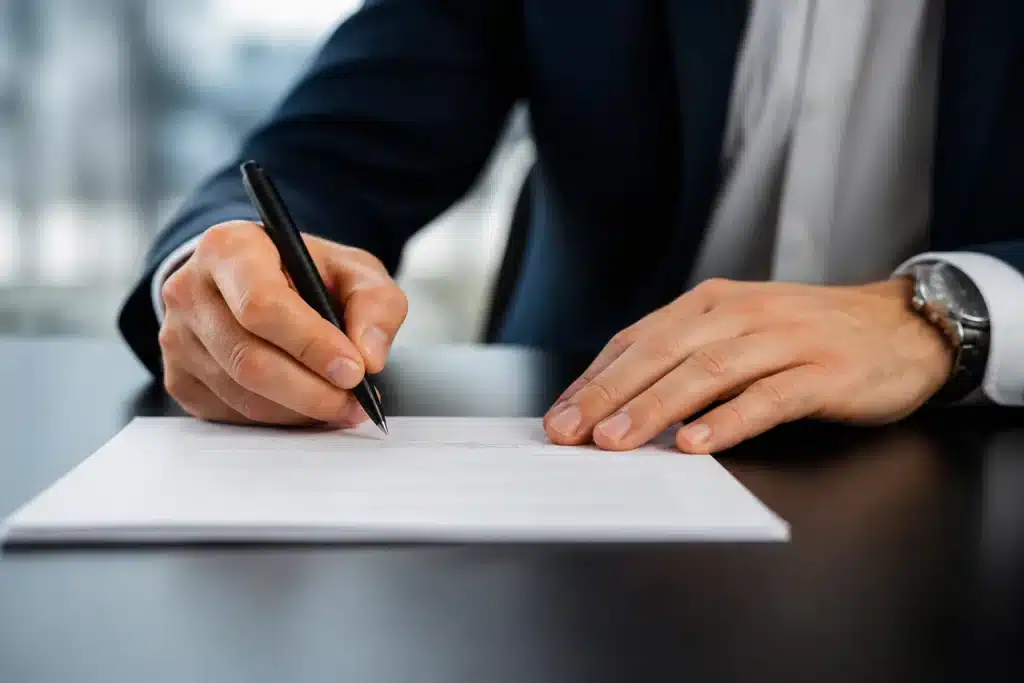 Personne signant document bancaire avec stylo noir