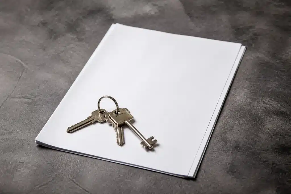 Contrat de bail papier avec clés sur surface grise