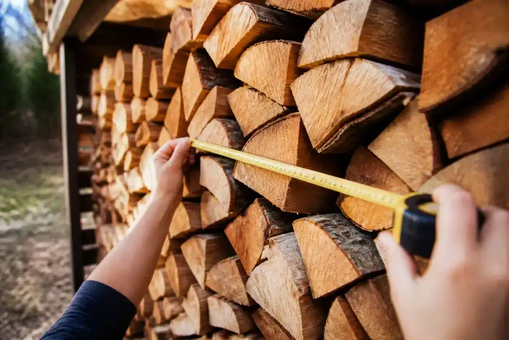 Tas de bois empilé mesuré avec mètre ruban