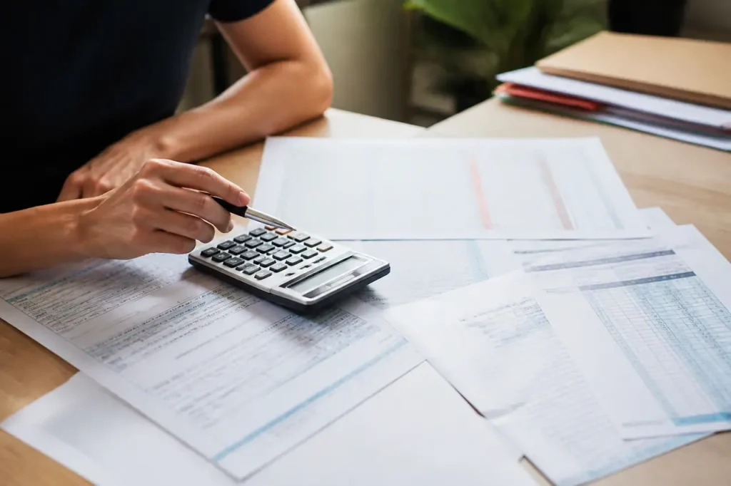 Bureau avec calculatrice stylo et feuilles de paie etalees