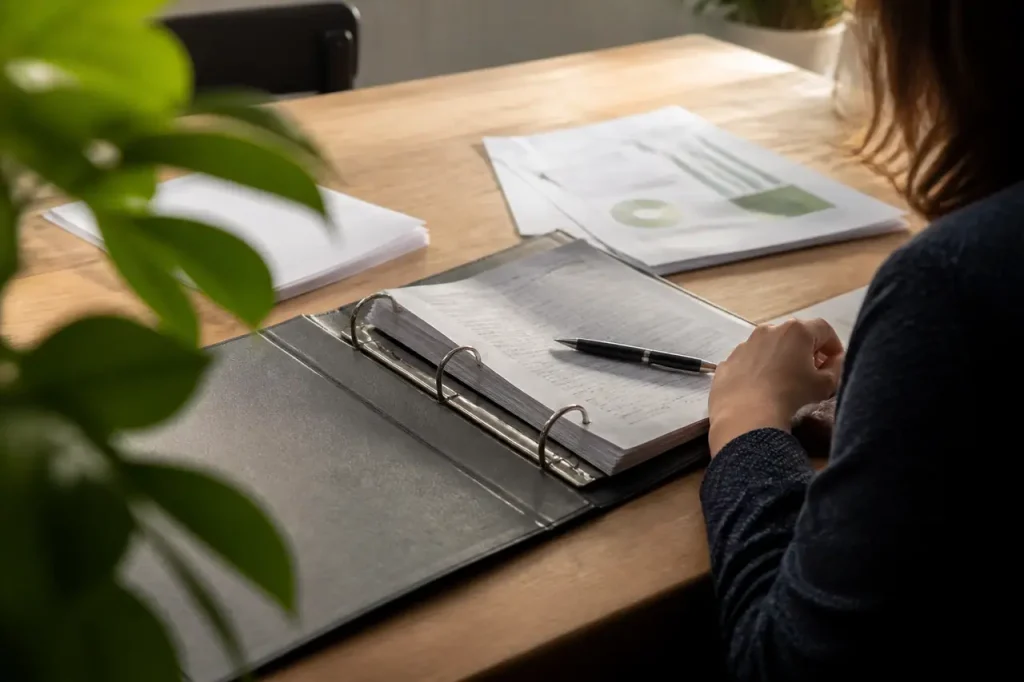 Classeur ouvert avec stylo et documents etales sur table