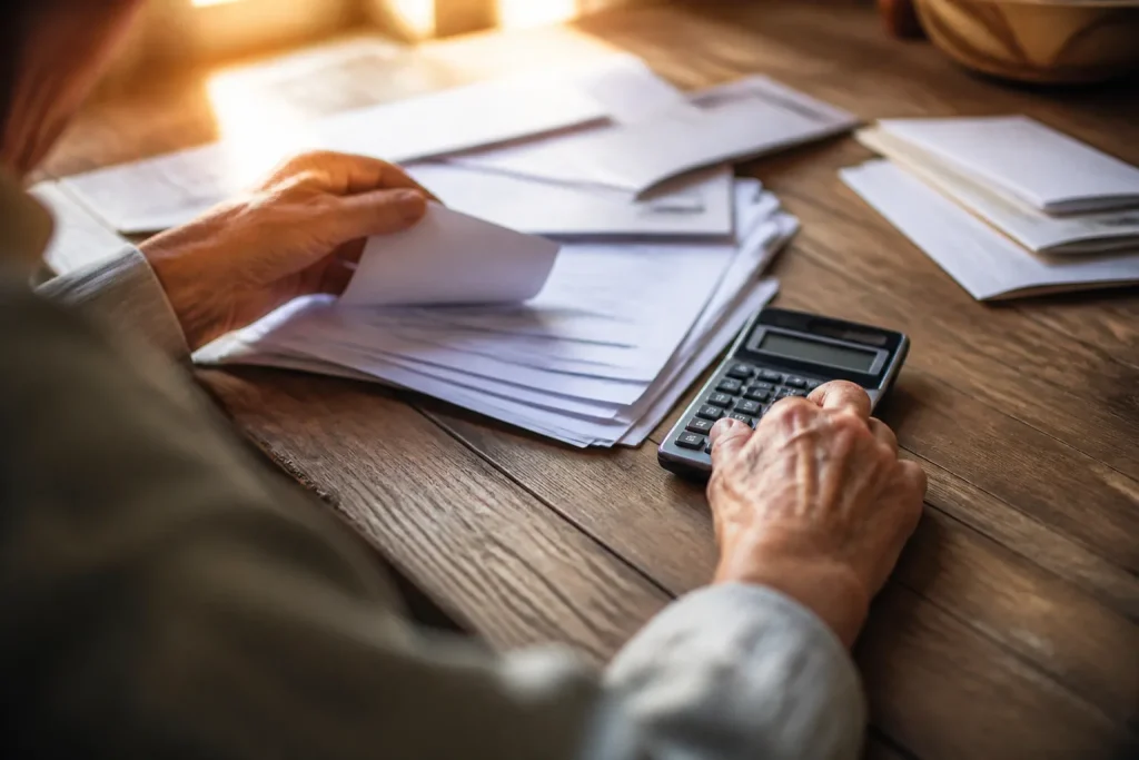 Pile de factures medicales et calculatrice sur un bureau
